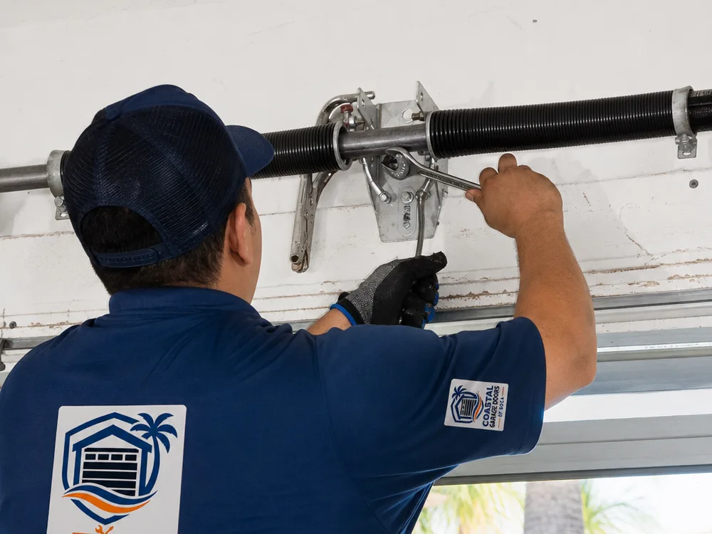 Technician working on a residential garage door torsion spring assembly